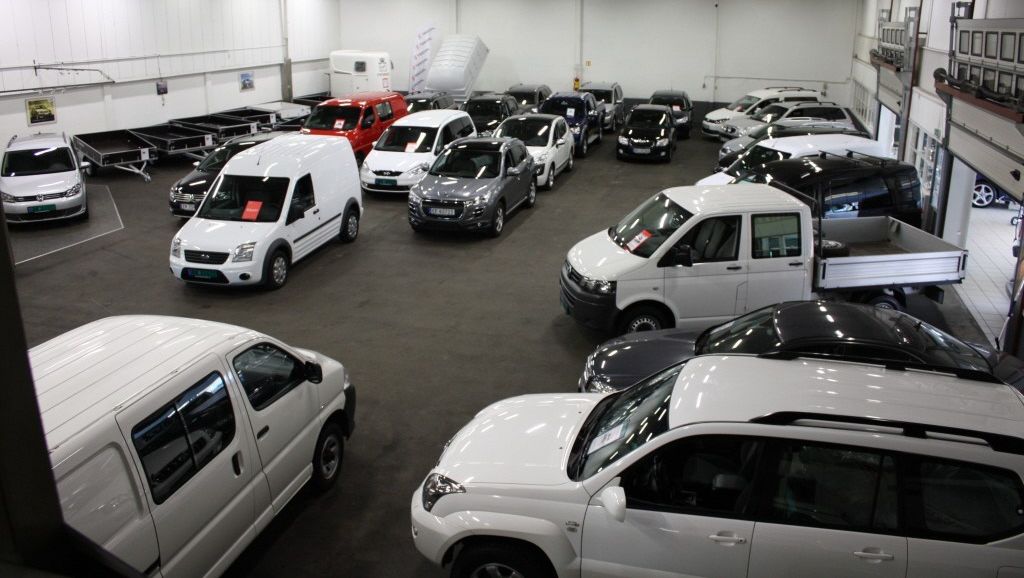 Mange biler står utstilt i en stor, lys hall